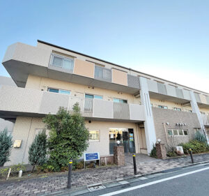 モダン設計の介護施設の建物外観。複数階建てで入口部分が見える。