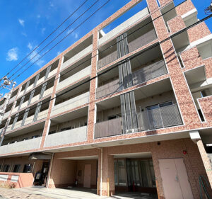 複数階の介護施設の建物外観。赤レンガと白いコンクリートの近代的な構造