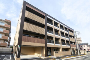 介護施設の建物外観。4階建てのモダンな施設建築で、窓が規則的に配置されている。